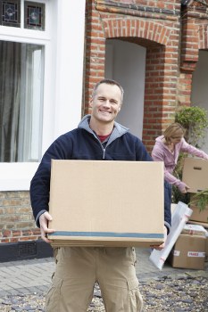 Movers carrying boxes through a Finchley property