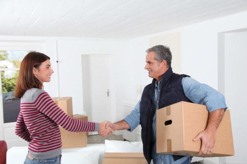 Removal team carrying household items through a Finchley property